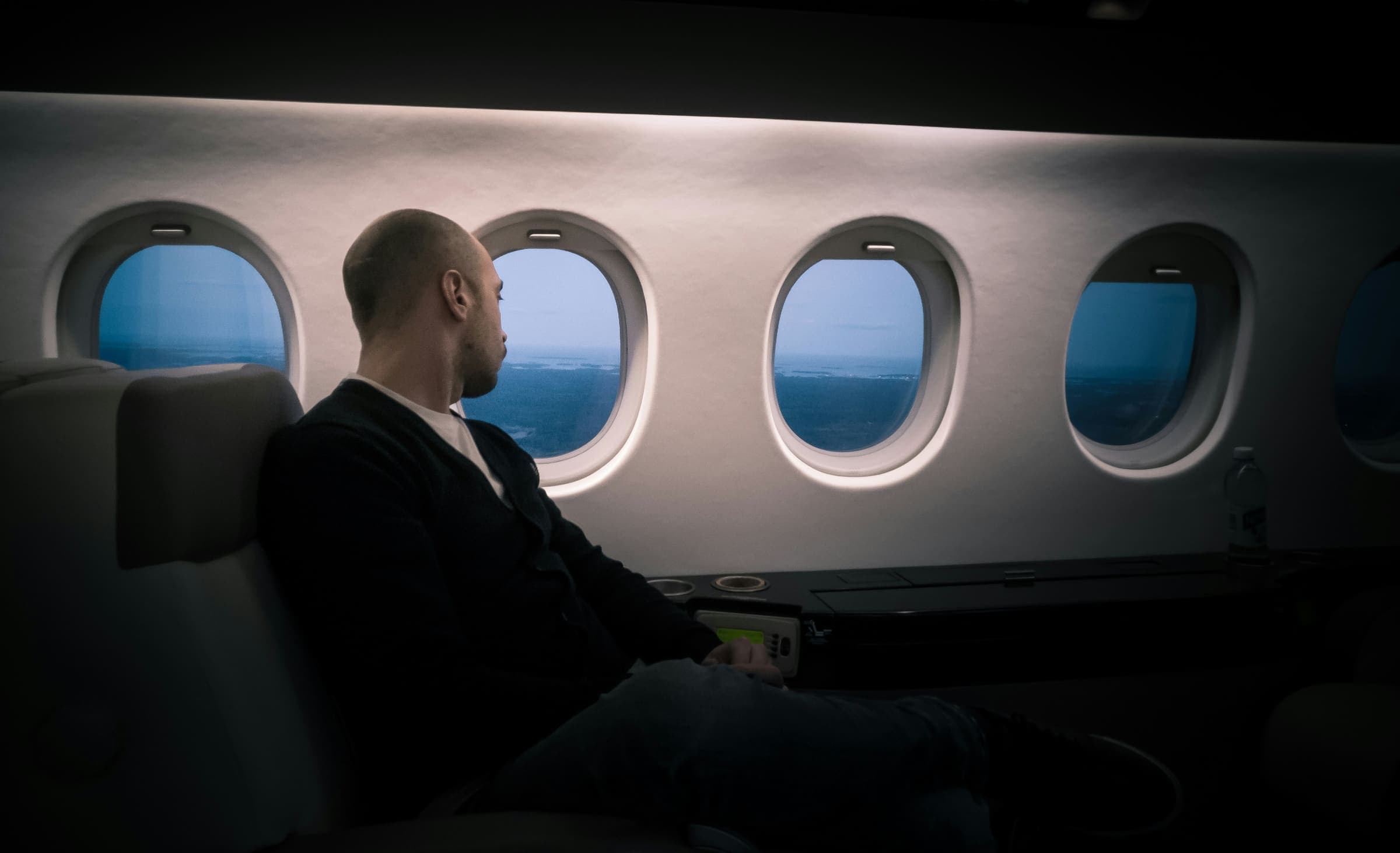 Un voyageur d'affaires regarde par le hublot d'une cabine d'avion
