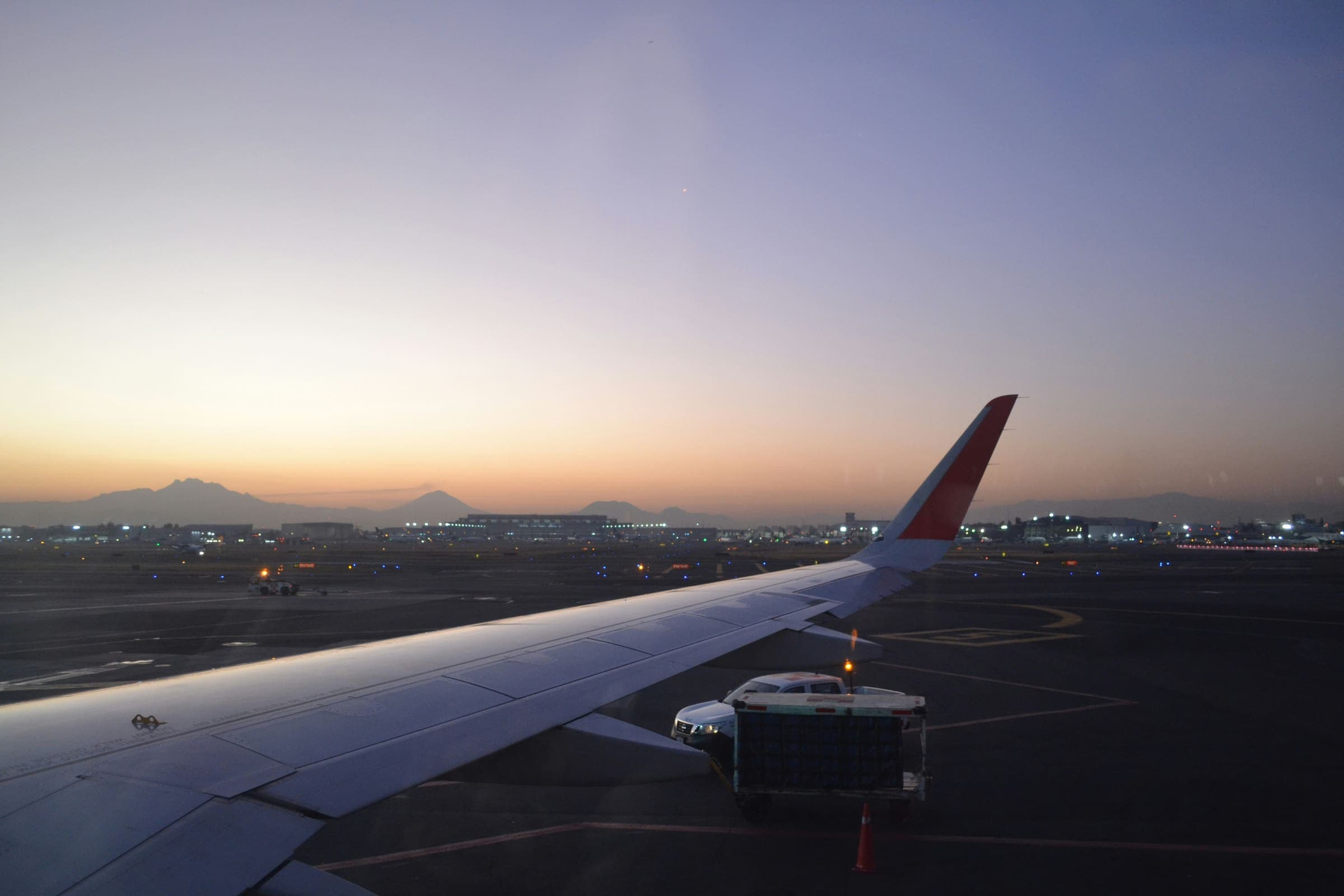 Aile d'avion au crépuscule, sur le tarmac avant le départ